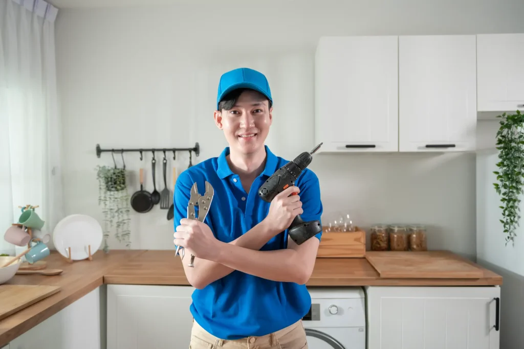 Versatile handyman fixing leaky kitchen faucet and clearing bathroom drain using plumbing tools in Dubai residential bathroom with efficiency and care